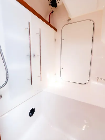  Yacht Photos Pics Interior of 2011 Dufour 40E Performance yacht, featuring sleek white surfaces and storage compartment.