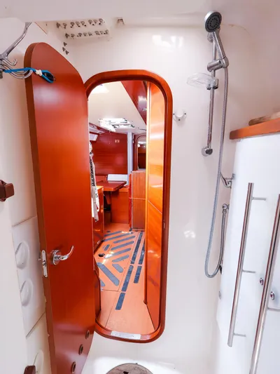  Yacht Photos Pics Interior of 2011 Dufour 40E Performance yacht, featuring a wooden door and shower area.