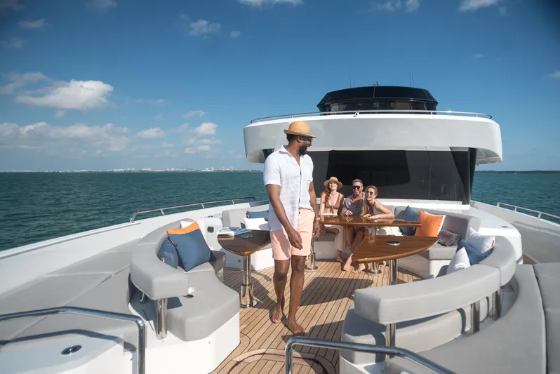  Yacht Photos Pics Luxury 2022 CL Yachts CLX96 with people enjoying the deck under a clear blue sky.