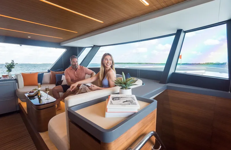  Yacht Photos Pics 2022 CL Yachts CLX96 interior with people enjoying the luxurious seating and ocean view.