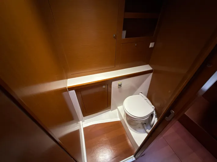 Samba Yacht Photos Pics Beneteau Oceanis 48 (2012) yacht bathroom with wooden cabinetry and compact toilet.