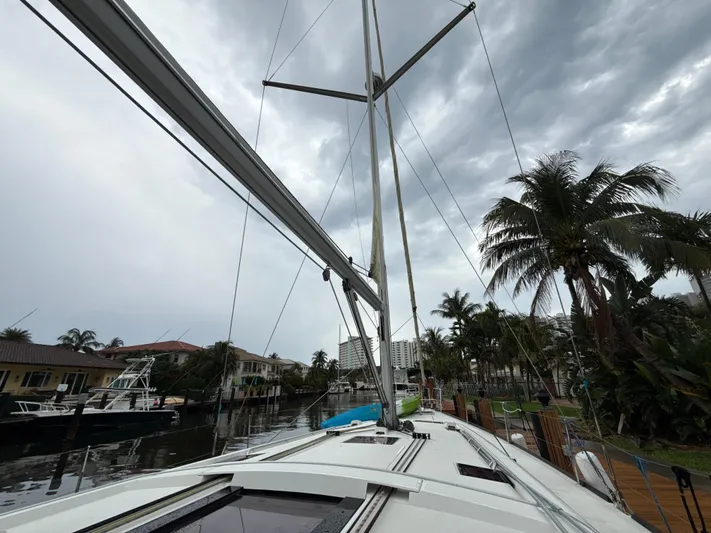 Samba Yacht Photos Pics 2012 Beneteau Oceanis 48 sailboat docked, with cloudy sky and palm trees in the background.