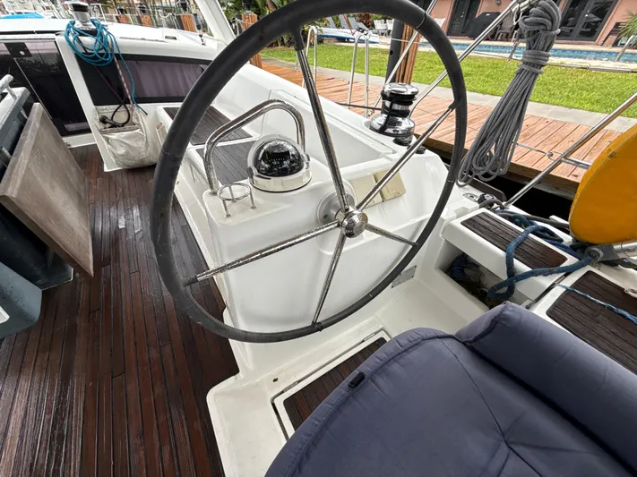 Samba Yacht Photos Pics Steering wheel of a 2012 Beneteau Oceanis 48 sailboat with wooden deck.