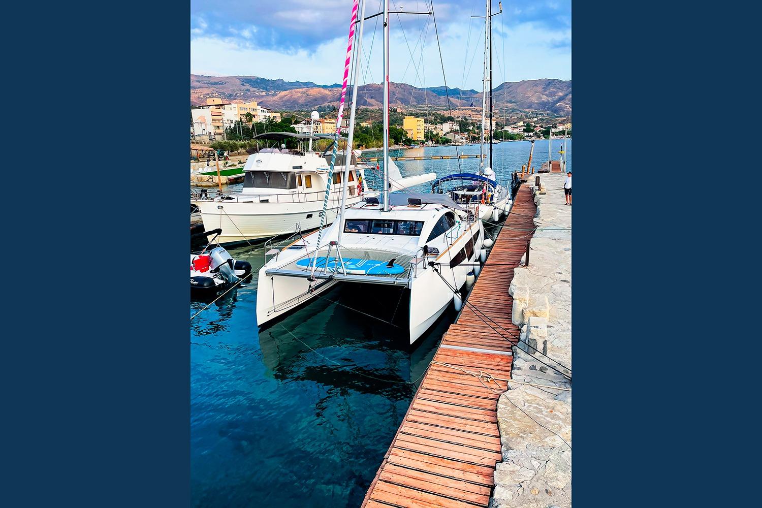 2021 Comar C-CAT 37 catamaran docked at a scenic marina with mountains.
