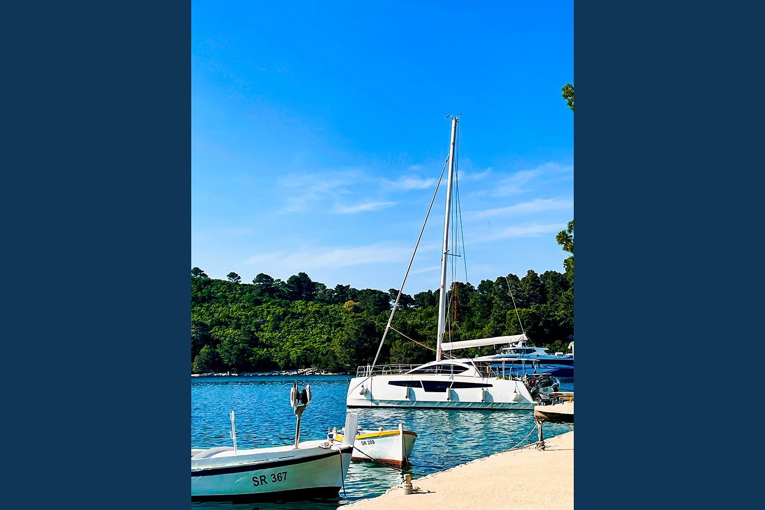 2021 Comar C-CAT 37 catamaran docked by a scenic shoreline.