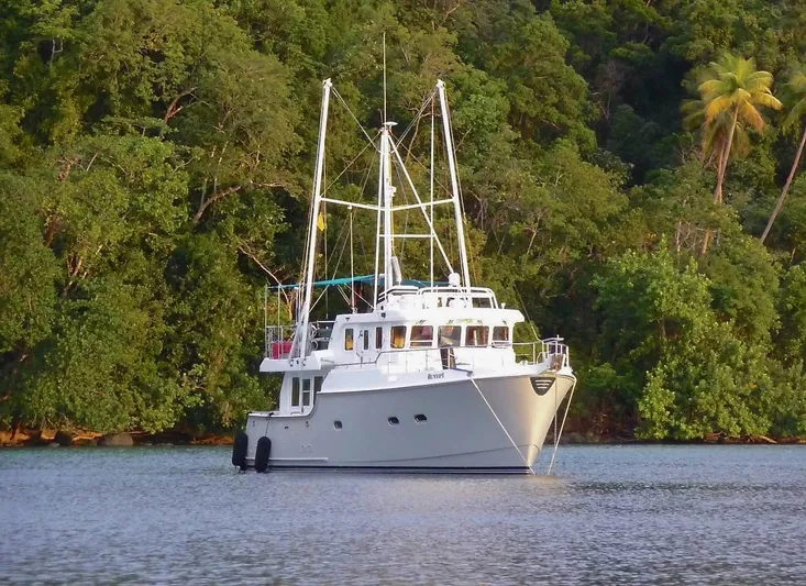 Bunyip I Yacht Photos Pics Nordhavn 47 yacht anchored in serene waters, surrounded by lush greenery, 2002 model.