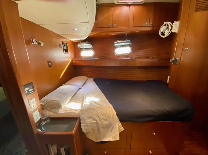 Bunyip I Yacht Photos Pics Cozy cabin interior of 2002 Nordhavn 47 yacht with wooden finish and comfortable bed.