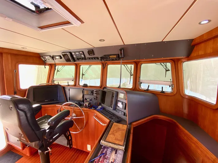 Bunyip I Yacht Photos Pics Pilothouse of 2002 Nordhavn 47 yacht with navigation equipment and wooden interior.