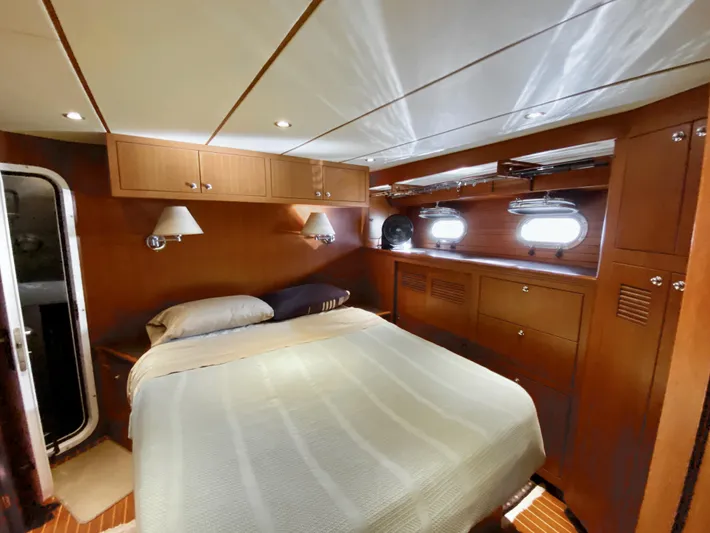 Bunyip I Yacht Photos Pics Luxurious cabin interior of 2002 Nordhavn 47 yacht with wood paneling and cozy bed.