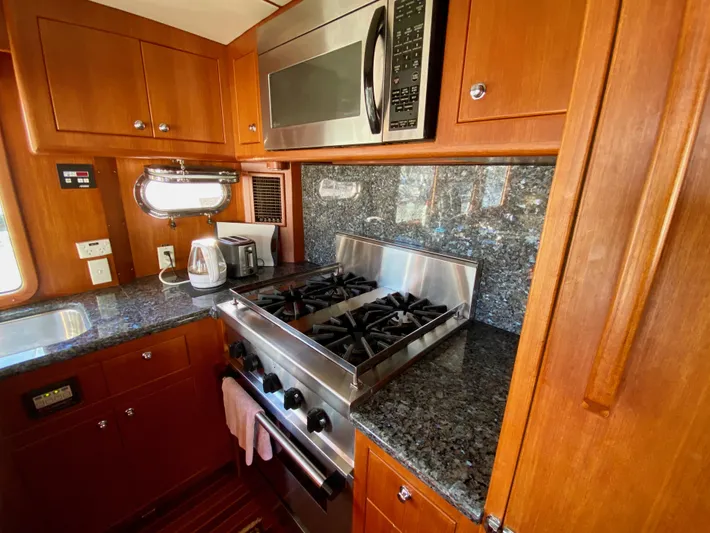 Bunyip I Yacht Photos Pics Luxurious kitchen in 2002 Nordhavn 47 yacht with granite countertops and stainless steel appliances.