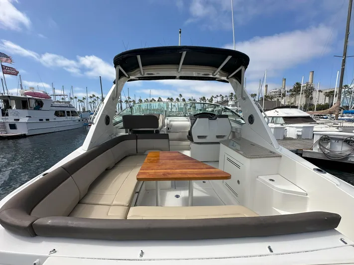 That's Amore Yacht Photos Pics 2015 Sea Ray 350 Sundancer yacht interior with seating and table, docked at marina.