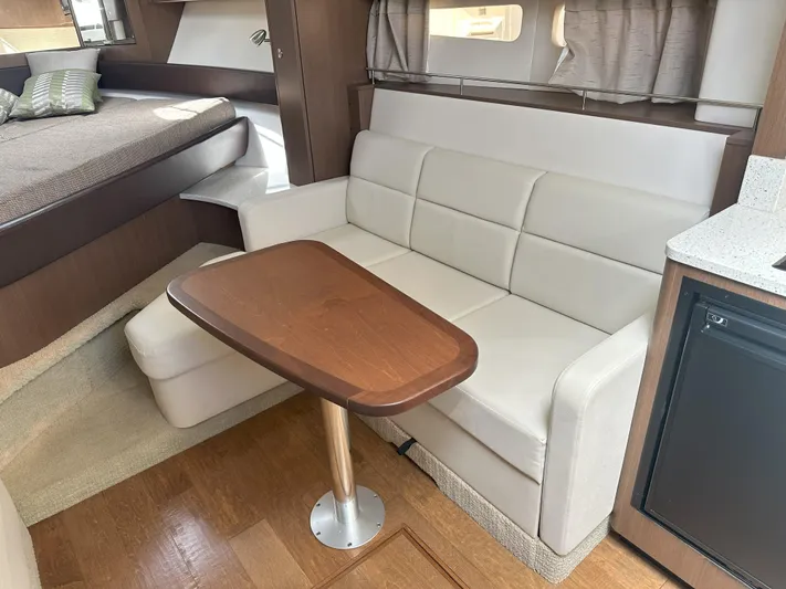 That's Amore Yacht Photos Pics Interior of 2015 Sea Ray 350 Sundancer with sofa, table, and bed.