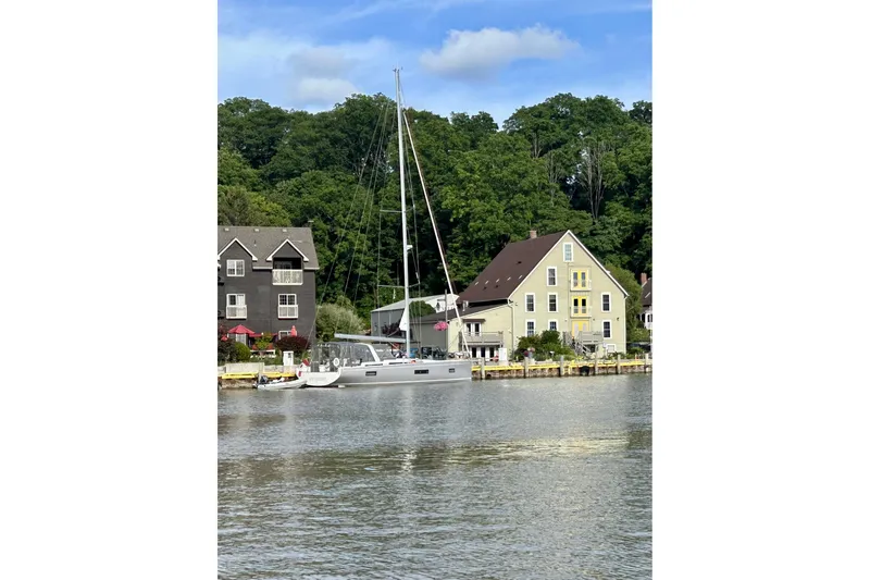 Spellbound Yacht Photos Pics 2022 Beneteau Oceanis Yacht 54 docked by charming waterfront homes.