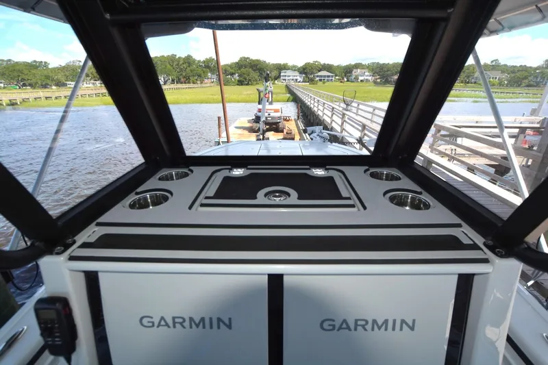 Carolina Bluewater Yacht Photos Pics 2024 Costa Custom Boats 264HC interior with Garmin equipment, docked by a scenic waterfront.