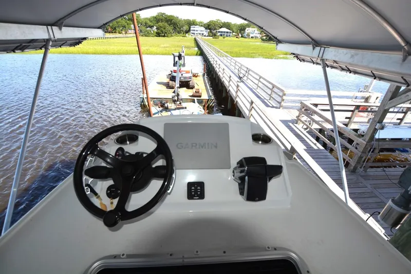 Carolina Bluewater Yacht Photos Pics 2024 Costa Custom Boats 264HC helm with Garmin navigation, docked by a scenic waterfront.