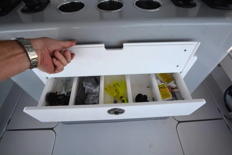 Carolina Bluewater Yacht Photos Pics Open storage drawer on 2024 Costa Custom Boats 264HC, showing organized fishing gear and supplies.