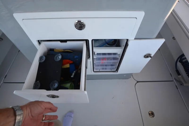 Carolina Bluewater Yacht Photos Pics 2024 Costa Custom Boats 264HC storage compartments with open drawers and visible fishing gear.