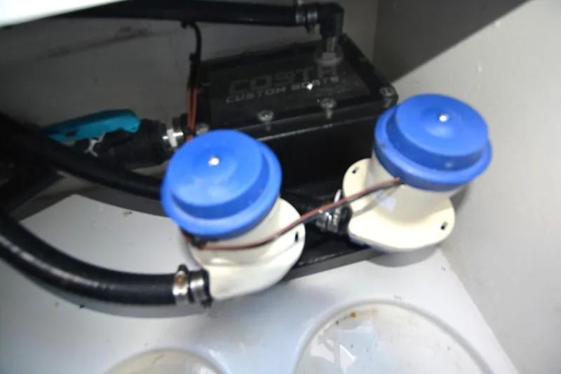 Carolina Bluewater Yacht Photos Pics 2024 Costa Custom Boats 264HC engine compartment with blue-capped components and wiring.