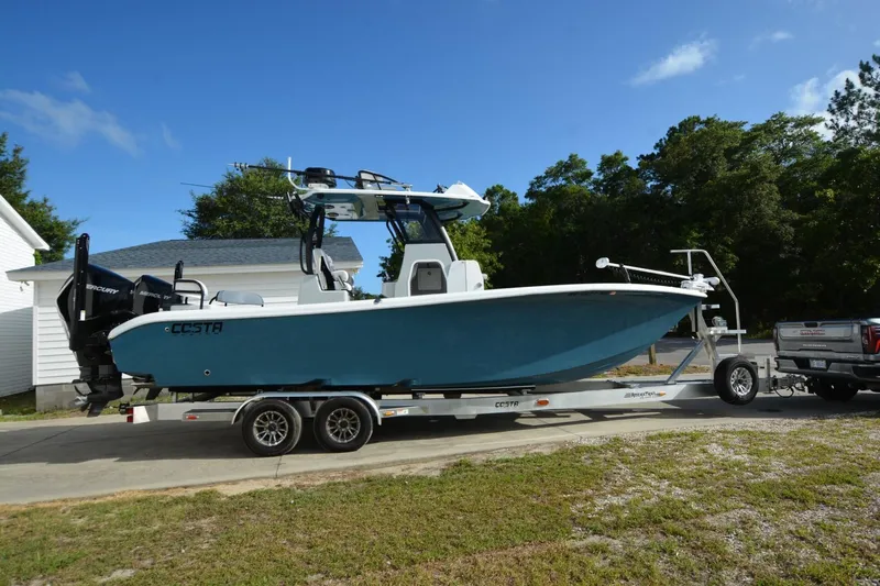 Carolina Bluewater Yacht Photos Pics 2024 Costa Custom Boats 264HC on trailer, parked outdoors, blue hull, dual Mercury engines.