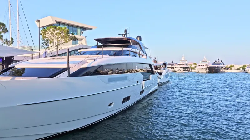 Eight44 Yacht Photos Pics 2025 Sanlorenzo SL90A yacht docked at marina, clear blue sky, modern architecture.