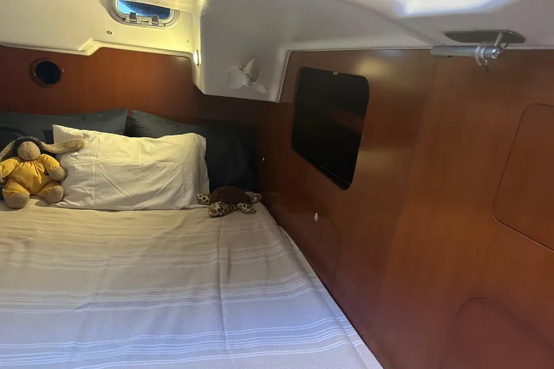  Yacht Photos Pics Cozy cabin interior of 2006 Beneteau Oceanis 523 with plush toys on bed.