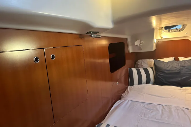  Yacht Photos Pics Interior cabin of 2006 Beneteau Oceanis 523 yacht with cozy bedding and wooden cabinetry.