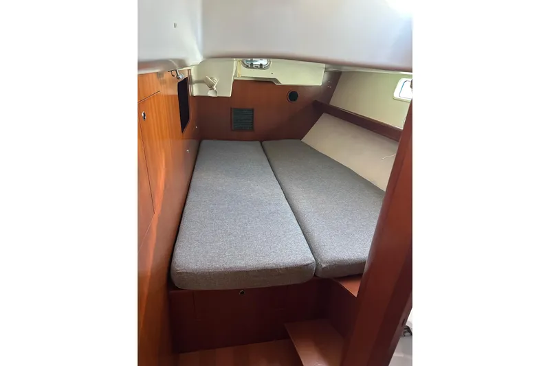  Yacht Photos Pics Cabin interior of 2006 Beneteau Oceanis 523 sailboat with wooden finish and gray cushions.