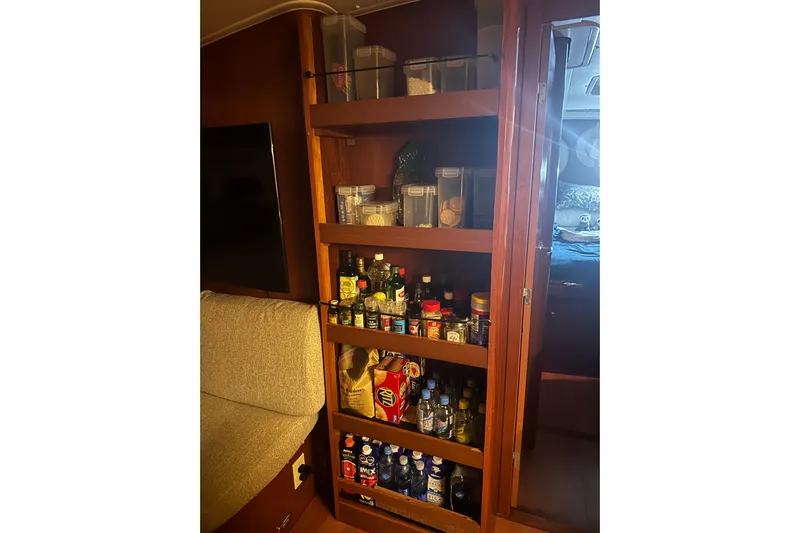  Yacht Photos Pics Interior of 2006 Beneteau Oceanis 523 showing well-stocked wooden pantry shelves.