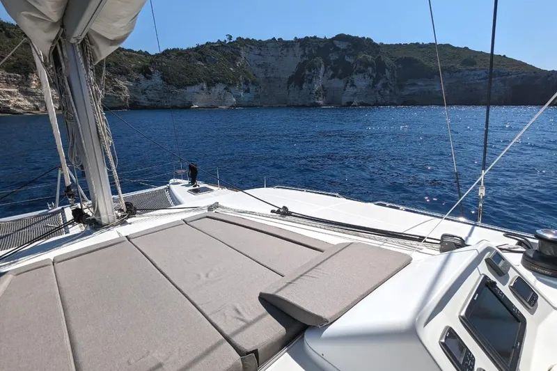 St Andrews Yacht Photos Pics Lagoon 450 F Owners Version 2014 sailing near rocky coastline under clear blue sky.