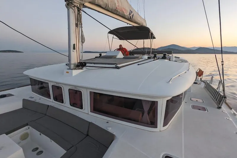 St Andrews Yacht Photos Pics 2014 Lagoon 450 F Owners Version catamaran sailing at sunset on calm waters.