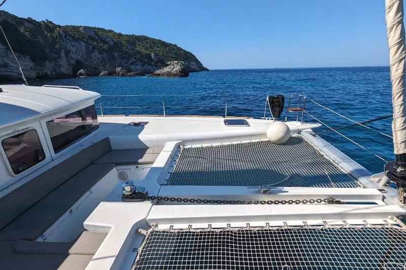 St Andrews Yacht Photos Pics 2014 Lagoon 450 F Owners Version catamaran on serene blue waters near rocky coastline.