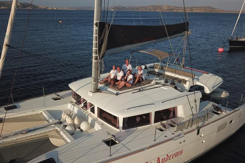 St Andrews Yacht Photos Pics 2014 Lagoon 450 F Owners Version catamaran with people relaxing on deck, sailing in calm waters.