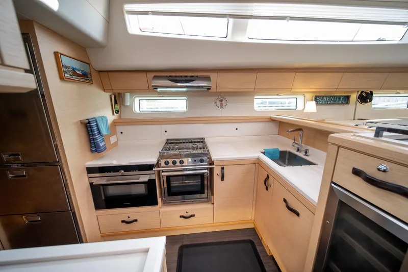 Serenity Yacht Photos Pics Luxurious Jeanneau 64 yacht kitchen interior, 2016 model, featuring modern appliances and sleek design.