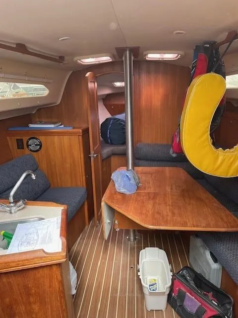 Interior of 2004 Hunter 306 sailboat with wooden furnishings and seating area.