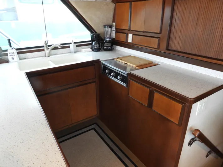  Yacht Photos Pics 1989 Bertram Convertible yacht kitchen with wood cabinets and modern appliances.