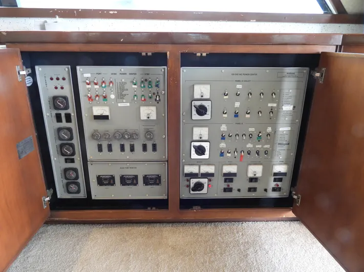  Yacht Photos Pics 1989 Bertram Convertible control panel with switches and gauges, housed in a wooden cabinet.