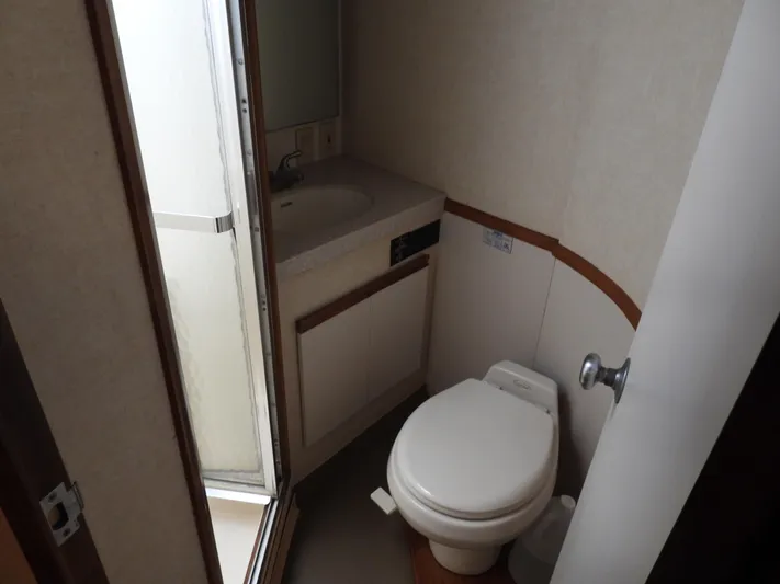  Yacht Photos Pics 1989 Bertram Convertible bathroom with toilet, sink, and shower.