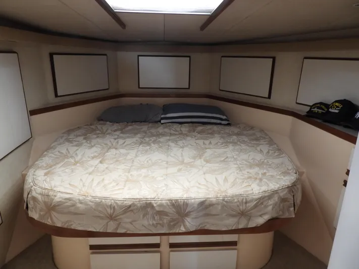  Yacht Photos Pics 1989 Bertram Convertible cabin with a cozy bed and nautical decor.