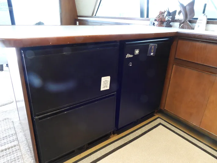  Yacht Photos Pics 1989 Bertram Convertible interior with black appliances and wooden cabinetry.