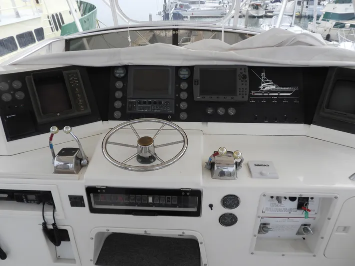  Yacht Photos Pics 1989 Bertram Convertible yacht dashboard with steering wheel and navigation controls.