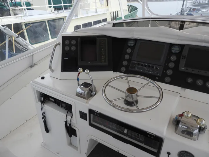  Yacht Photos Pics 1989 Bertram Convertible yacht helm with steering wheel, controls, and navigation equipment.