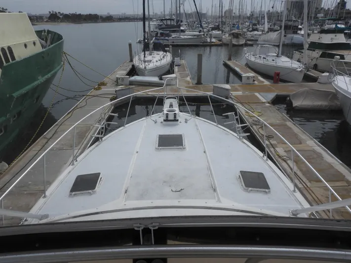  Yacht Photos Pics 1989 Bertram Convertible yacht docked at marina, surrounded by other boats.