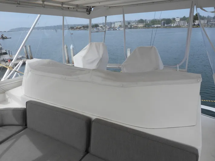  Yacht Photos Pics 1989 Bertram Convertible yacht interior with covered seating, overlooking a serene waterfront view.