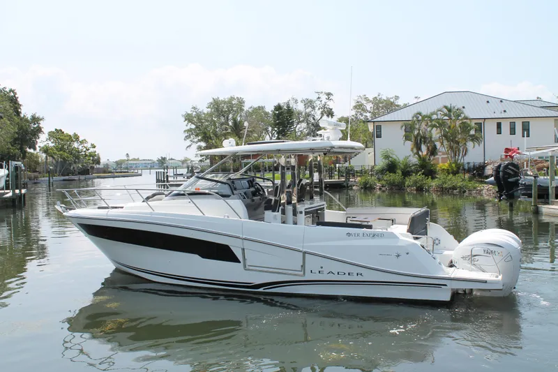 Over Exposed Yacht Photos Pics 2021 Jeanneau Leader 10.5 boat on a calm waterway near residential area.