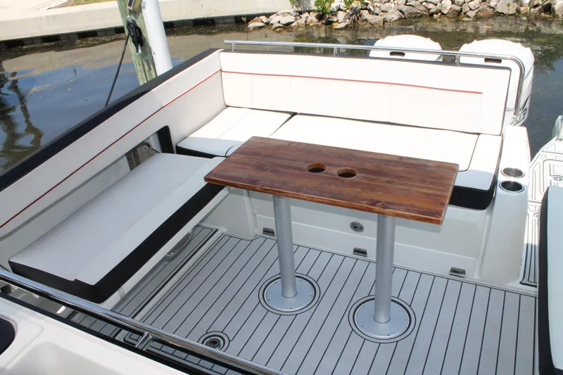 Over Exposed Yacht Photos Pics 2021 Jeanneau Leader 10.5 boat interior with seating and wooden table.