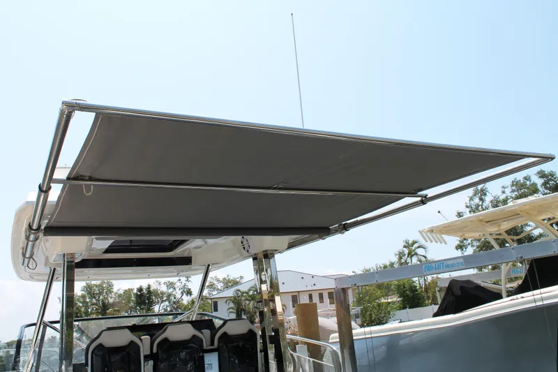 Over Exposed Yacht Photos Pics 2021 Jeanneau Leader 10.5 boat with sunshade canopy, showcasing sleek design and comfort.