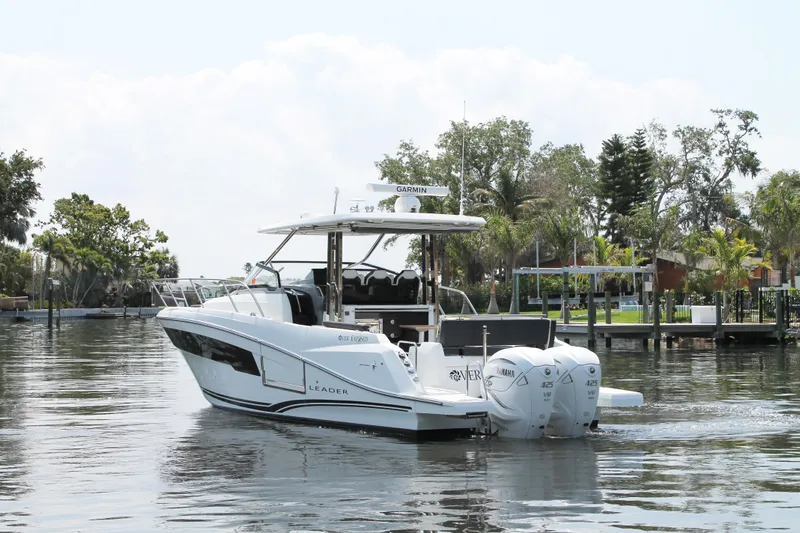 Over Exposed Yacht Photos Pics 2021 Jeanneau Leader 10.5 boat cruising on a calm lake with trees in the background.