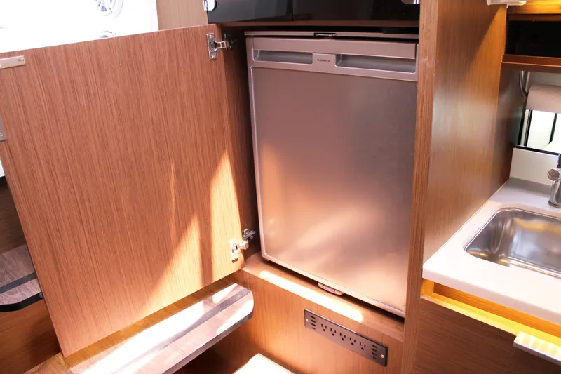 Over Exposed Yacht Photos Pics 2021 Jeanneau Leader 10.5 interior with compact fridge and sink.