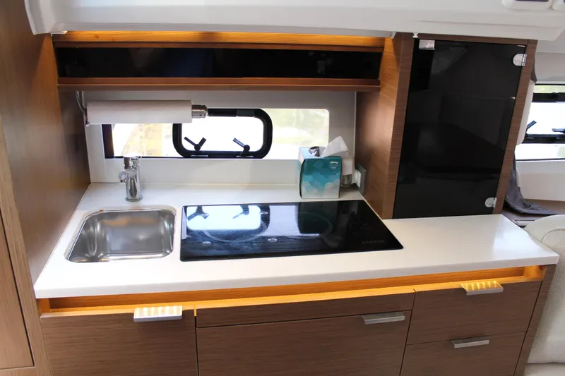 Over Exposed Yacht Photos Pics 2021 Jeanneau Leader 10.5 yacht kitchen with sink, stove, and storage cabinets.