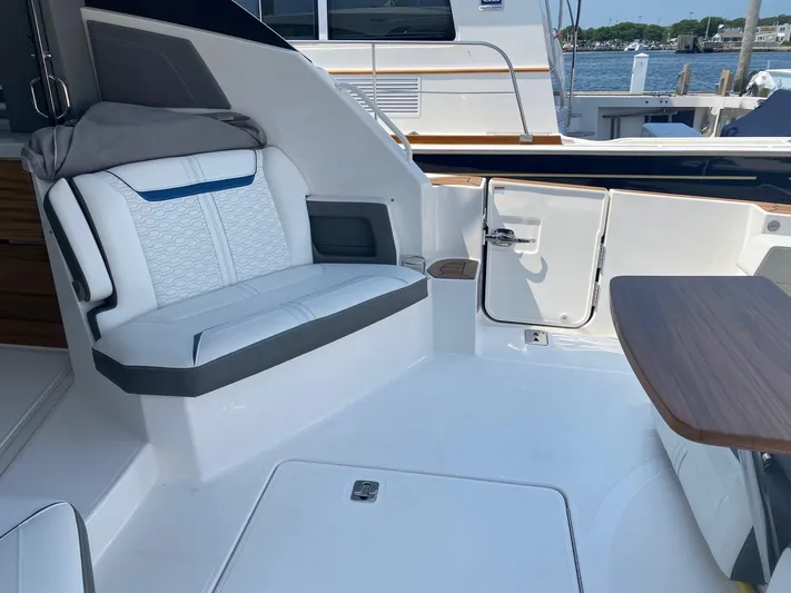  Yacht Photos Pics 2021 Tiara Yachts 43 LE interior with white seating and wooden table, docked at marina.